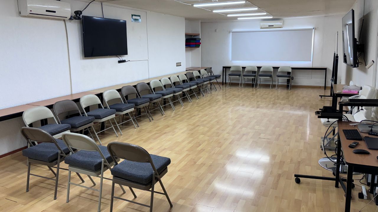 Aula con sillas alrededor y pantalla al frente