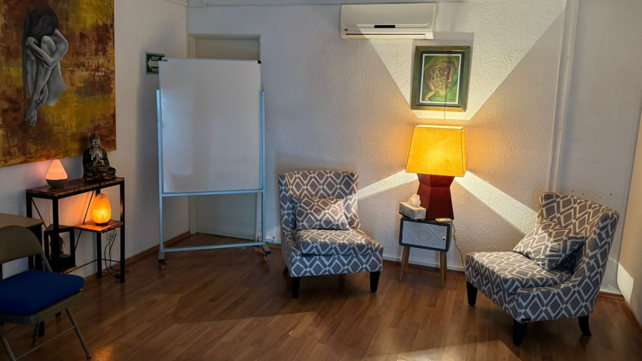Consultorio con dos sillones, lámpara cálida y pizarrón